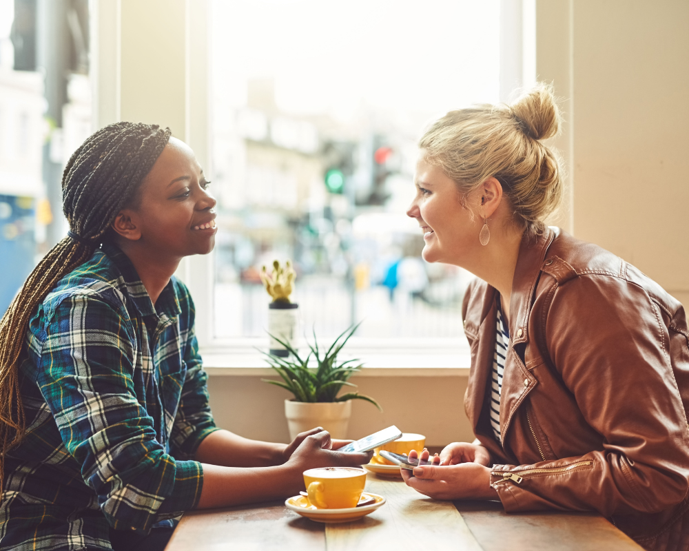 twee vrouwen drinken koffie en praten met elkaar
